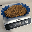Green mountain water process decaf coffee beans from Mexico in a blue container weighed on a Dymo digital scale